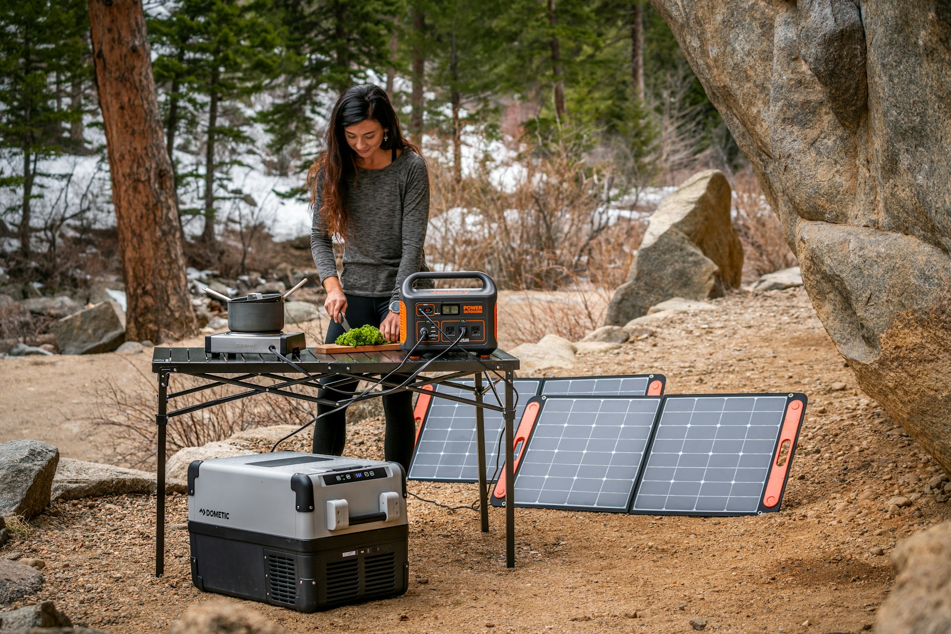 Powerstation mit Solarpanels beim Camping und Kochen im Freien.