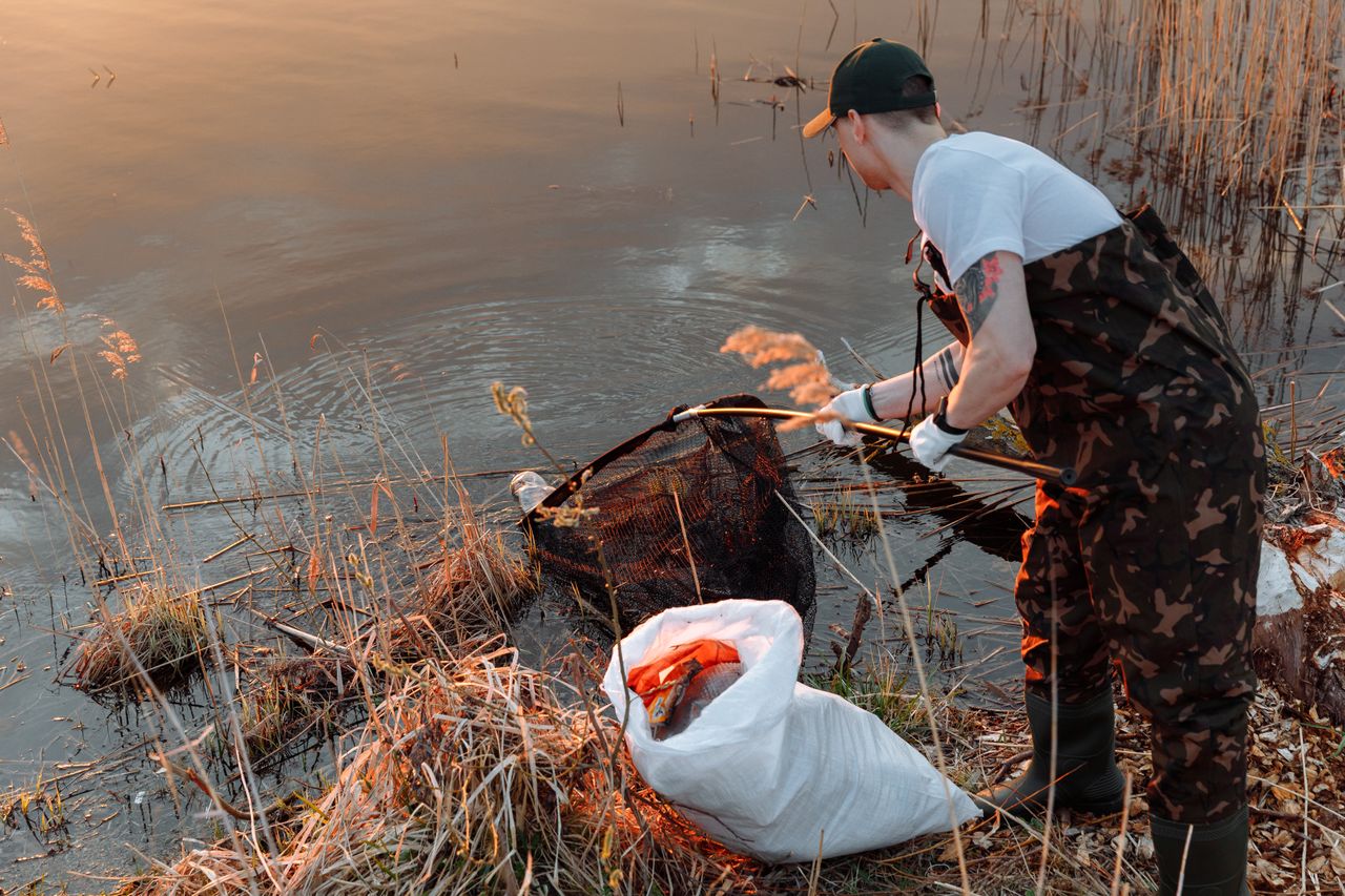 Mann reinigt einen Teich